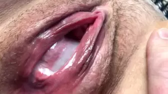 Spunk flows from a chunky, swollen and poked up twat. Close-up.