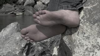 Feet of a cougar woman on the river bank.