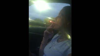 Gorgeous mature smoking cigarettes while in car